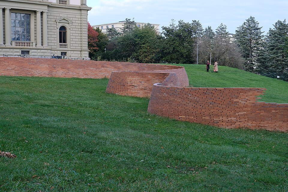 Jacques Kaufmann's brick wall zigzagging over the grass of the Ariana park