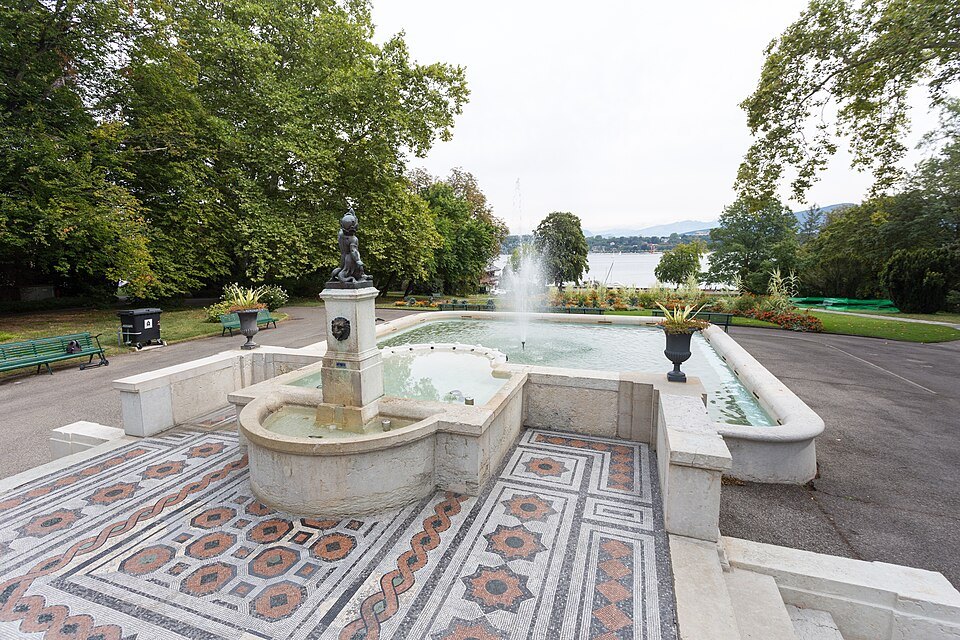 A fountain on a mosaic terrace at the Perle du Lac, the lake beyond