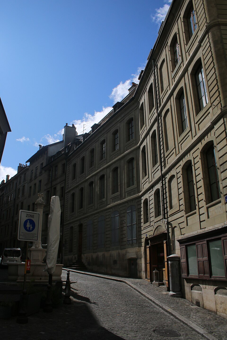 A narrow old-town street between high stone walls