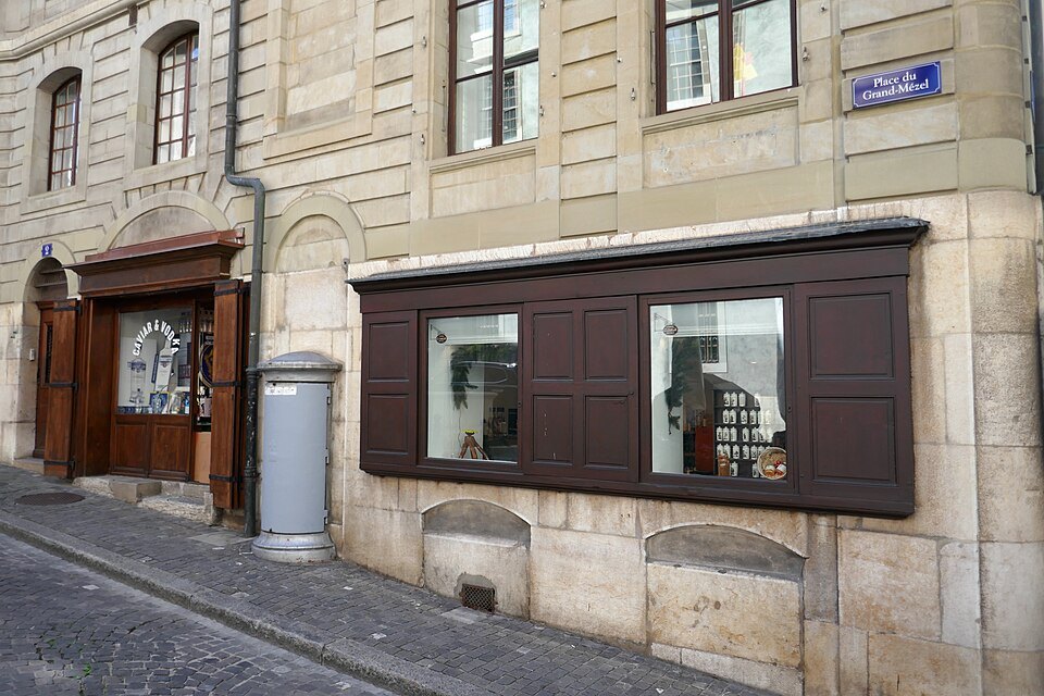 Old shopfronts with wooden shutters on the Place du Grand-Mézel