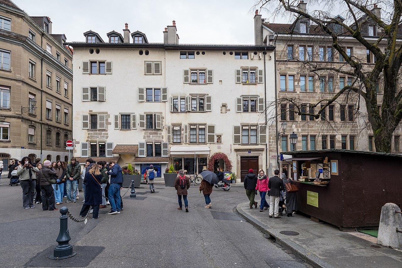People crossing the Place du Bourg-de-Four in front of its tall shuttered houses