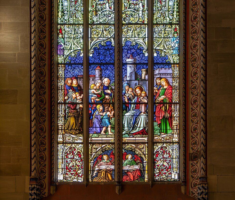 A stained-glass window of saints in deep blues and reds in the cathedral
