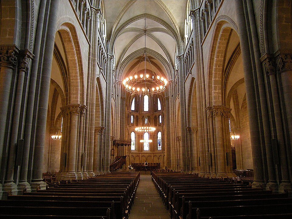 The cathedral nave in warm light, its chandelier hanging over the pews