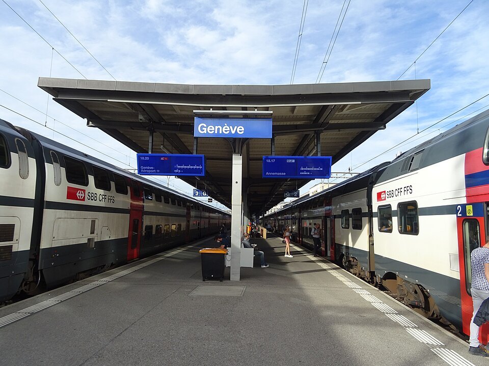 Double-deck trains either side of a platform signed Genève