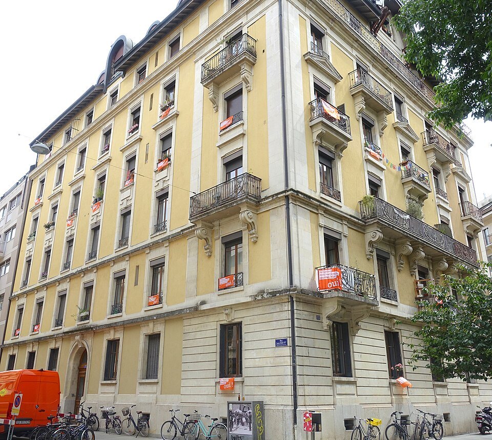 A yellow apartment building with iron balconies on the Rue Jean-Jaquet in the Pâquis