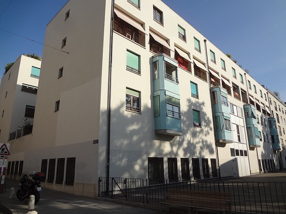 A modern apartment block with green bay windows in the Pâquis