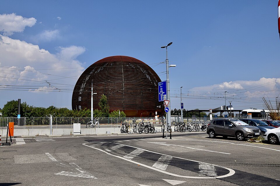 CERN's Globe beyond a roundabout and parked cars