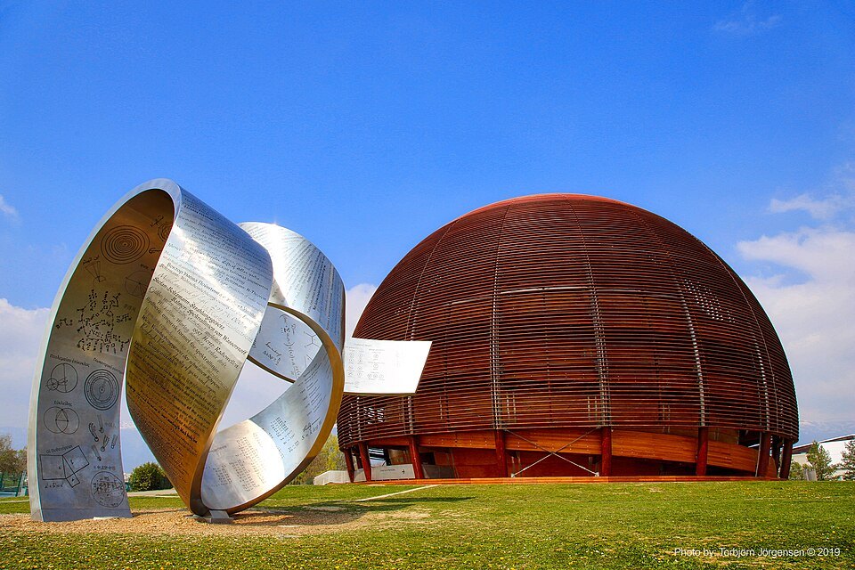 CERN's wooden Globe of Science and Innovation beside a steel ribbon sculpture