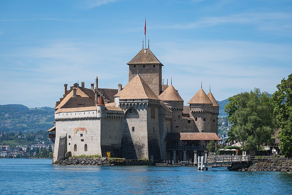 Chillon Castle on its rock in the lake, its towers against a blue sky