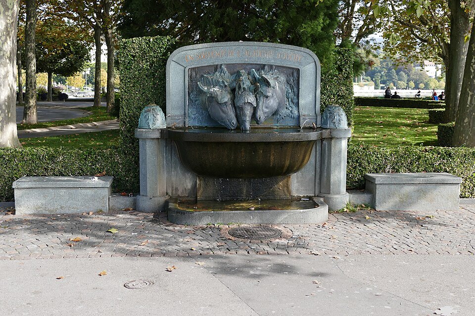 A stone fountain with a carved relief in a park at Ouchy