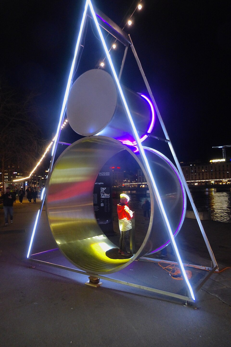 A luminous ring and triangle installation on the quay during Geneva Lux