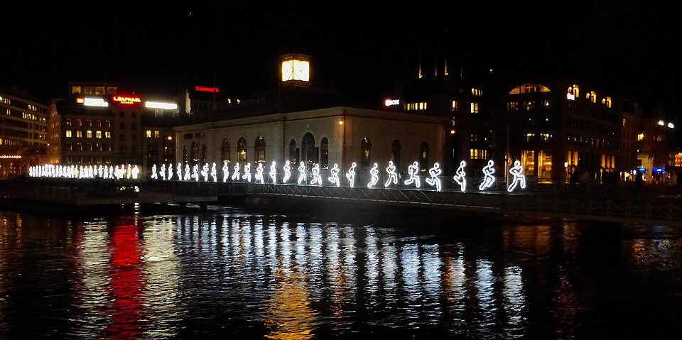 A line of glowing figures along the Rhône during the Geneva Lux festival