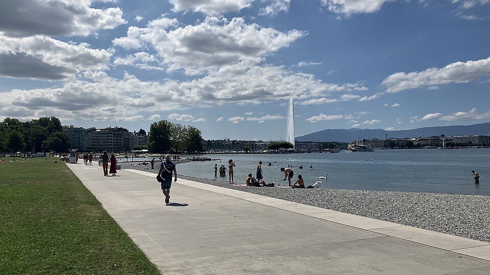 Walkers on the lakeside promenade at Eaux-Vives, the Jet d'Eau offshore