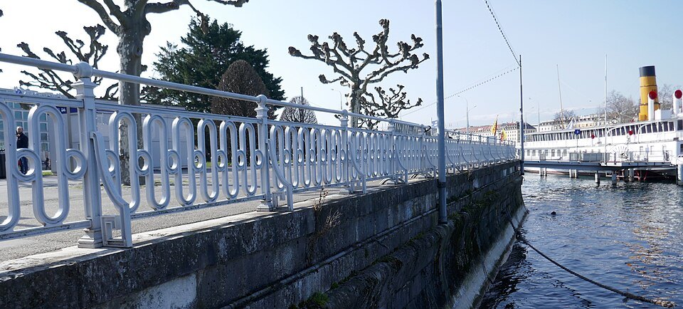 White railings along the Jardin Anglais landing, a paddle steamer moored beyond