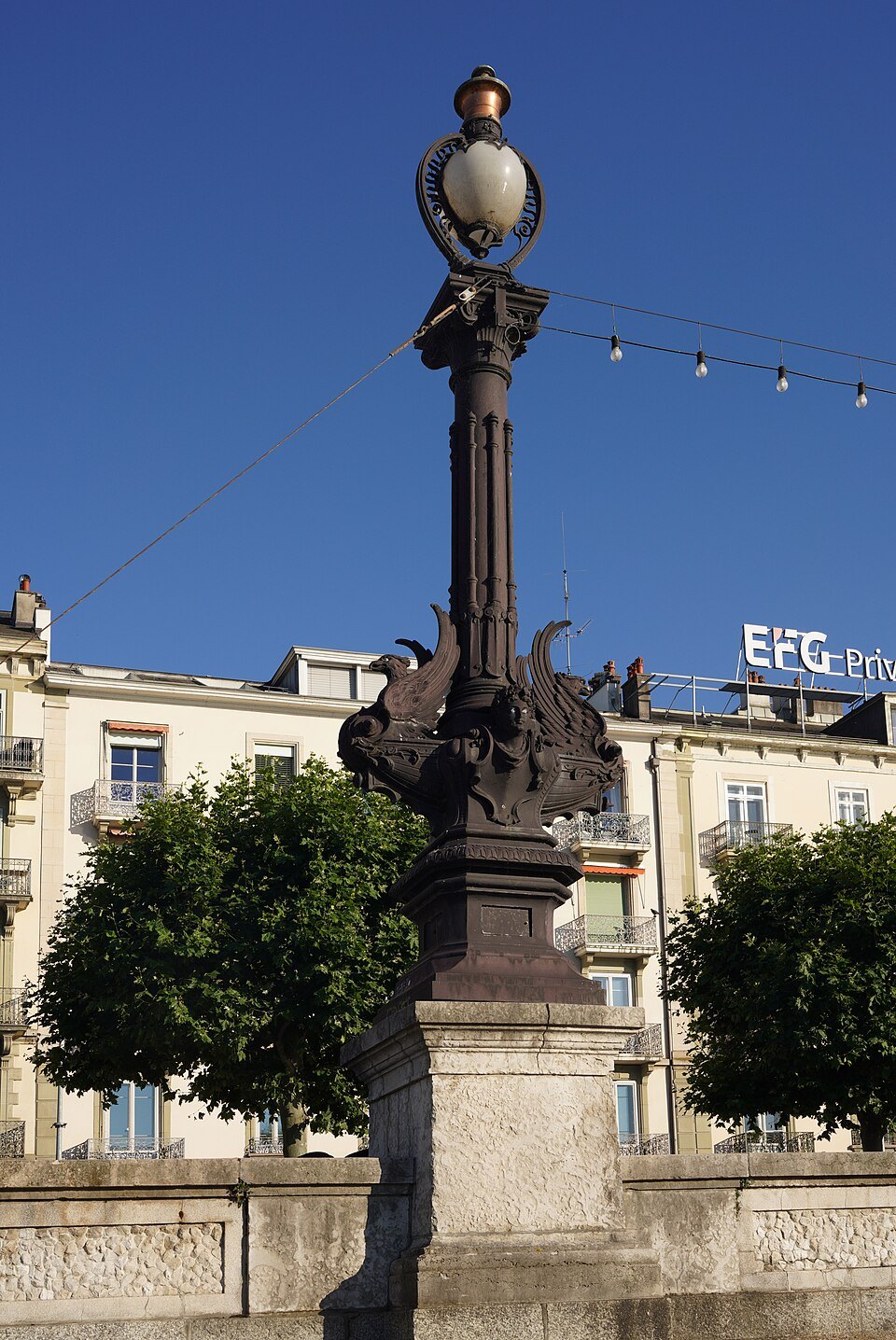 An ornate cast-iron lamppost on the lakefront quay