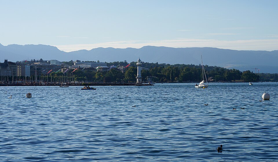 The harbor and its lighthouse under a pale sky, the Jura in the distance