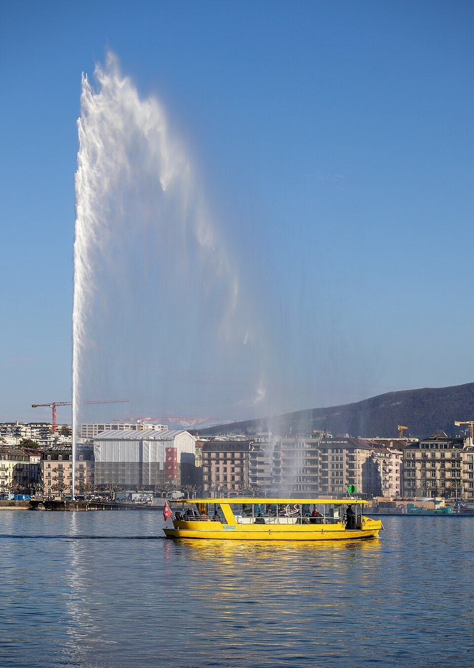 A yellow Mouette crossing in front of the Jet d'Eau