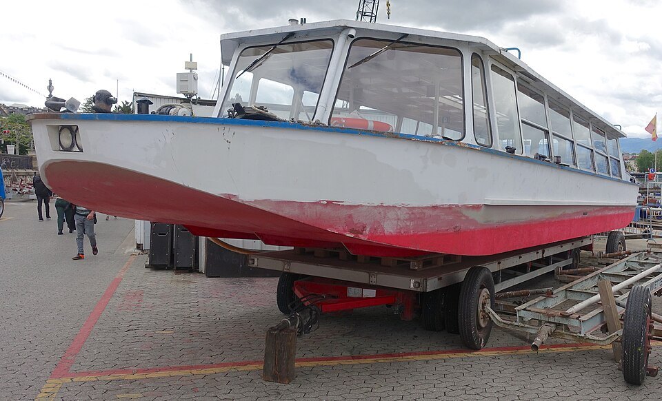 A water bus hauled out on a trailer on the Eaux-Vives quay