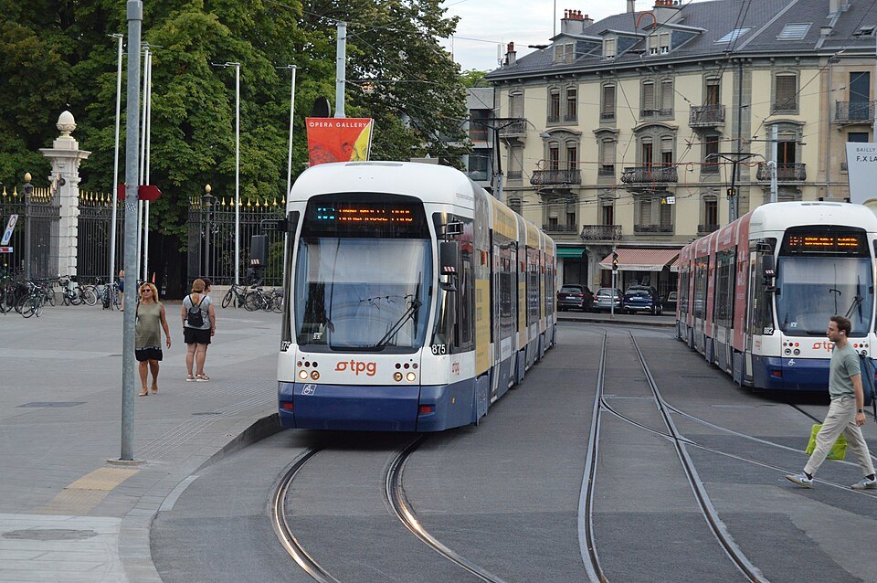 Two trams passing on a square, apartment buildings behind
