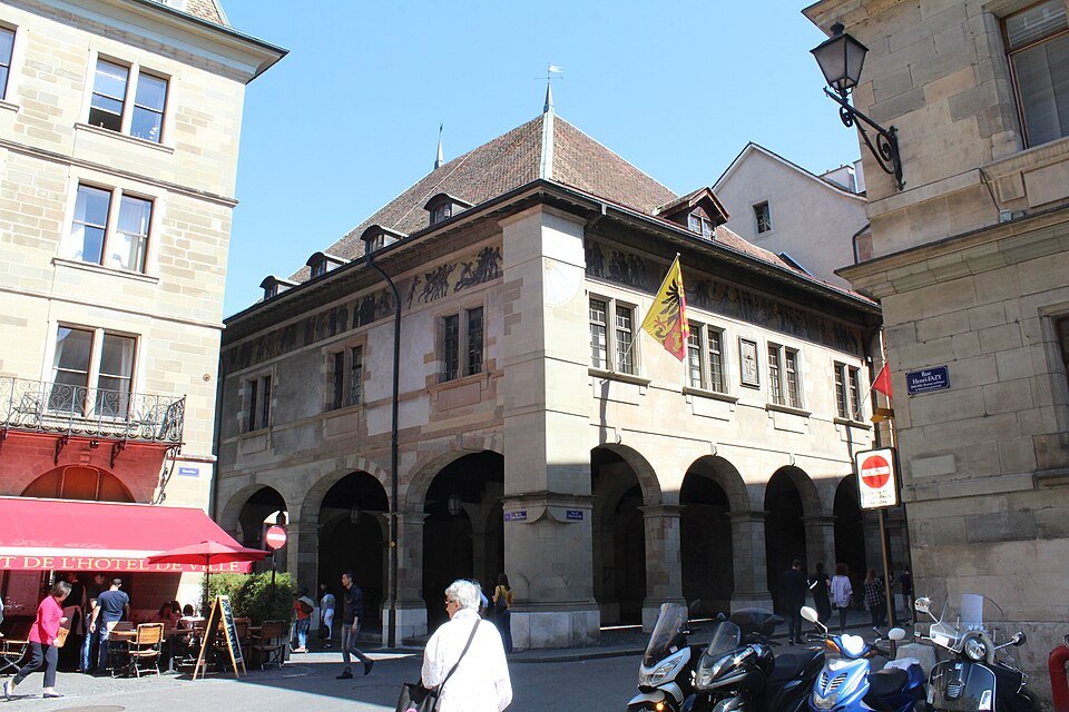 The Old Arsenal's arcades and the flag of Geneva on a sunny day in the old town