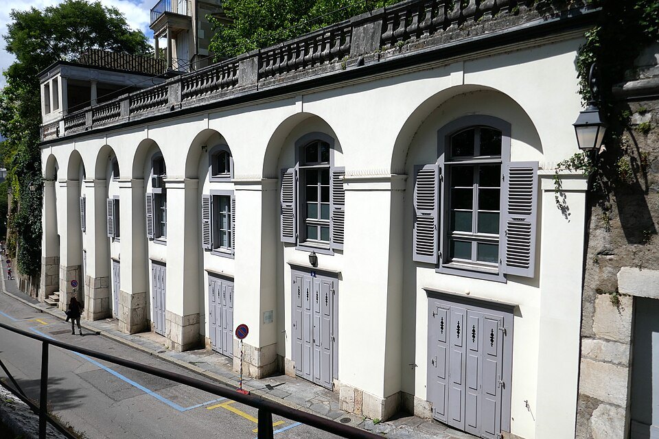The arched white facade of the houses on the Rampe de la Treille