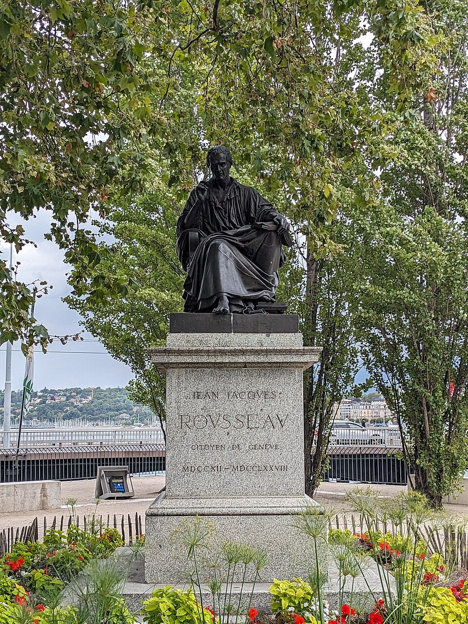 Rousseau's bronze statue seated on its pedestal among the flowers of the island