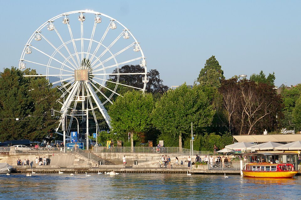A Ferris wheel above the trees and quay of the Jardin Anglais