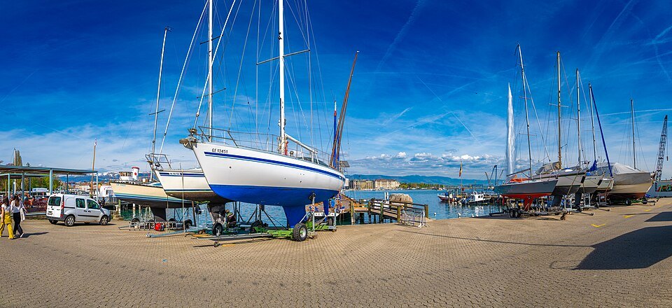 Sailboats laid up on the harbor quay under a blue sky