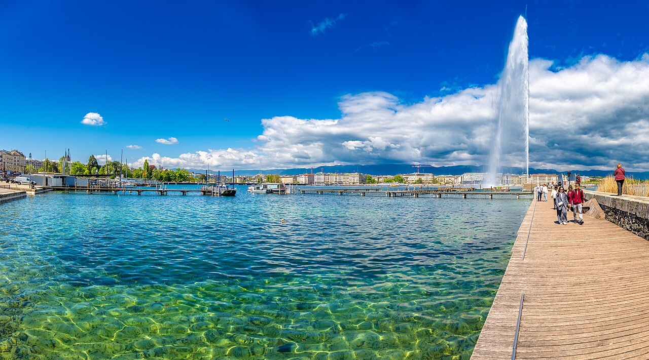 The Jet d'Eau above clear turquoise shallows beside the Eaux-Vives jetty