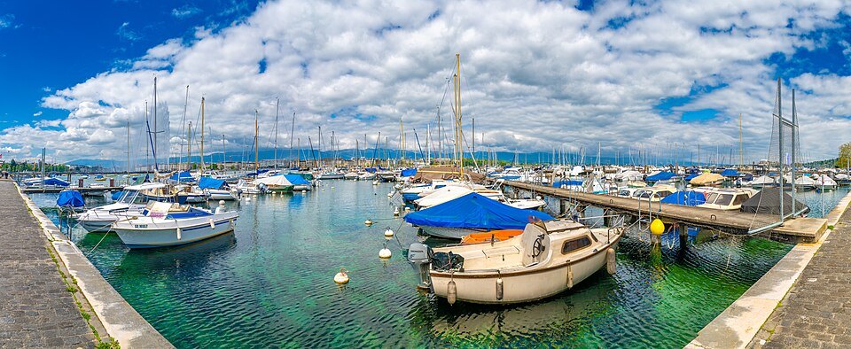 Moored boats in the Eaux-Vives marina under a sky full of clouds