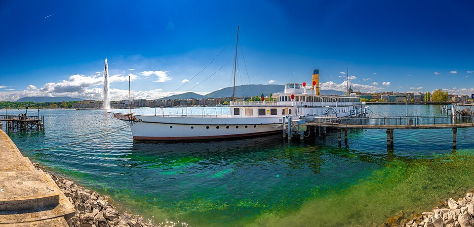 A paddle steamer moored at the lakefront, the Jet d'Eau in the distance