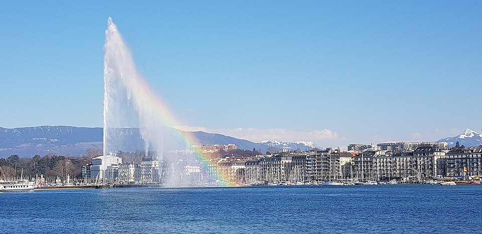 A rainbow across the Jet d'Eau, the left-bank buildings and the Salève beyond