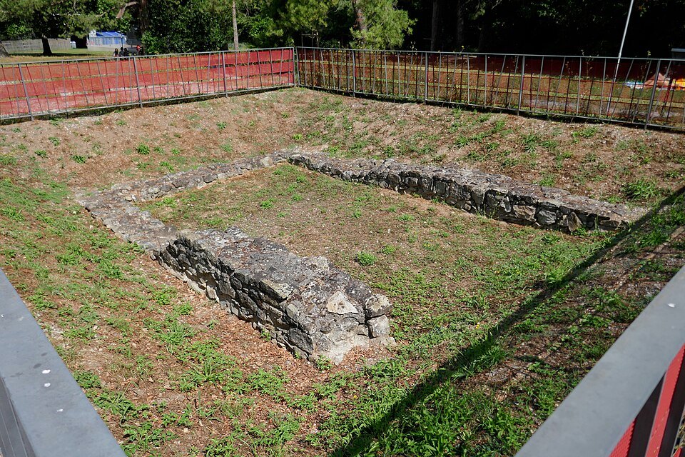 Low Roman walls excavated in a fenced patch of Parc La Grange