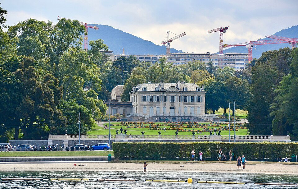 Villa La Grange above its lawns and the lakeshore, cranes on the skyline behind
