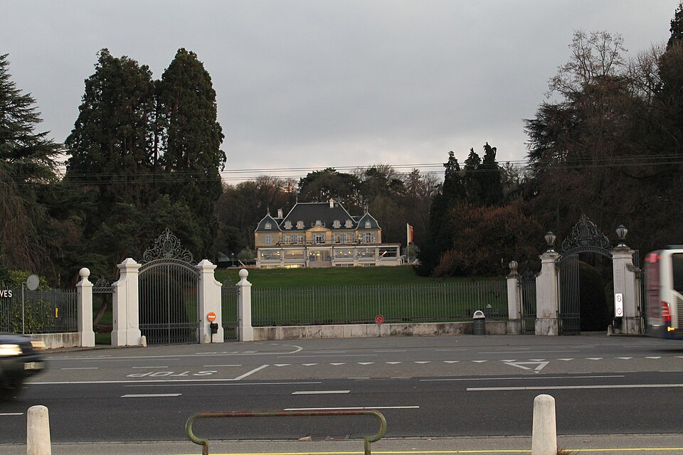 A lakeside villa seen through its gates from the road