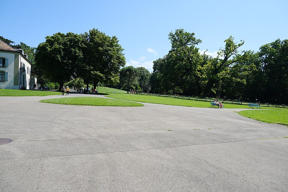 An open lawn and old trees in Parc La Grange