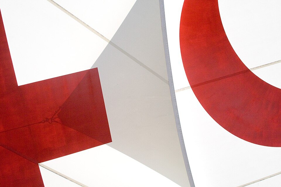 Red shapes of a large abstract cross in the museum's white atrium