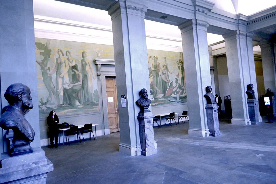 Bronze busts under the painted walls of the university hall at the Bastions