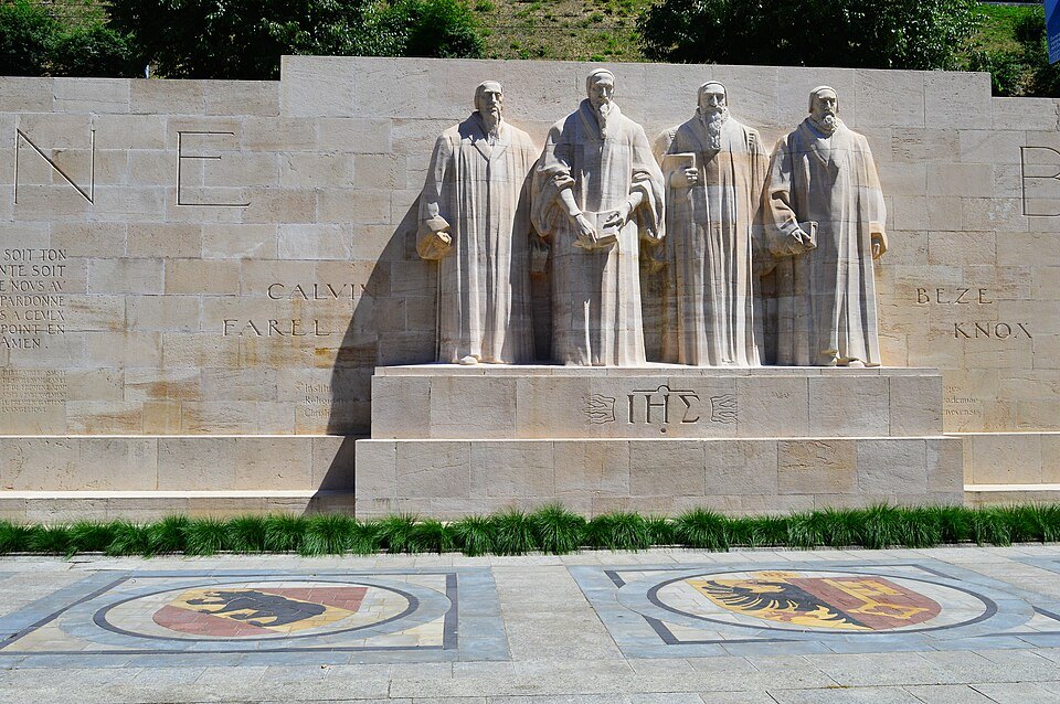 Calvin, Farel, Beza and Knox carved in stone, with the arms of Geneva set in the paving before them